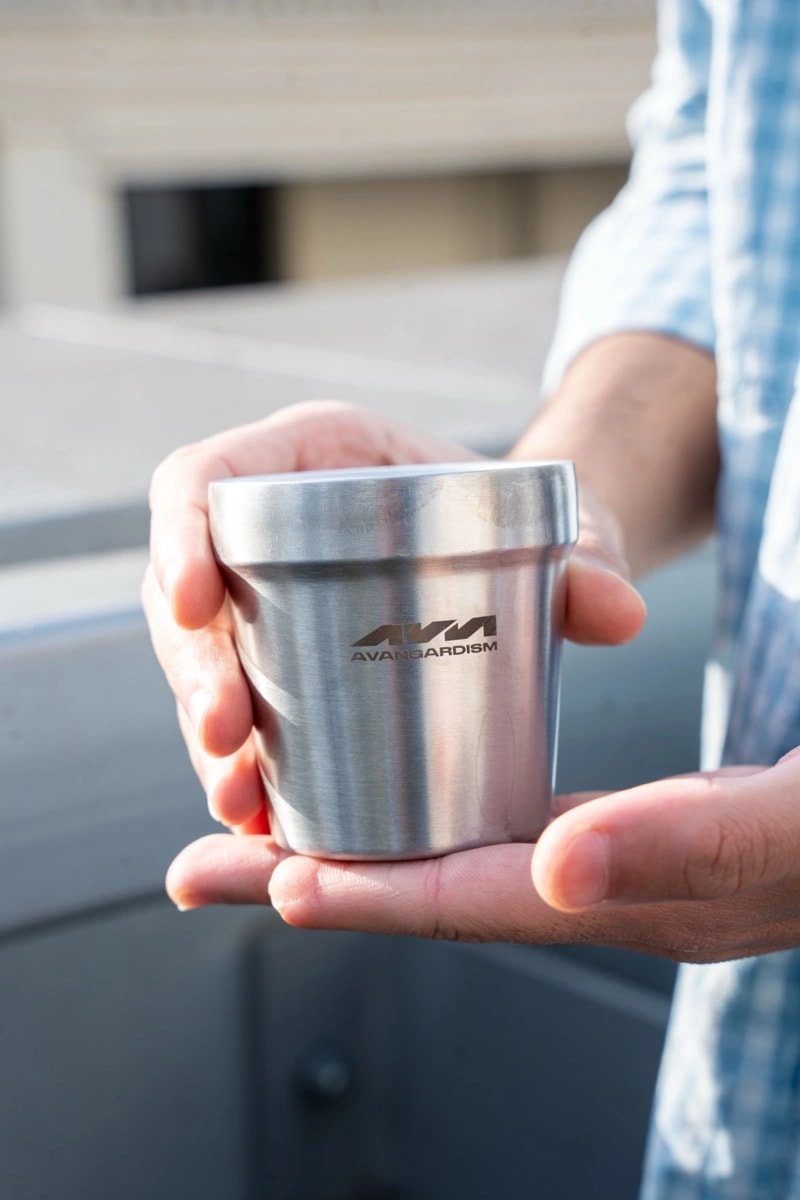 Une tasse AVANGARDISM tendue pour accueillir un échange