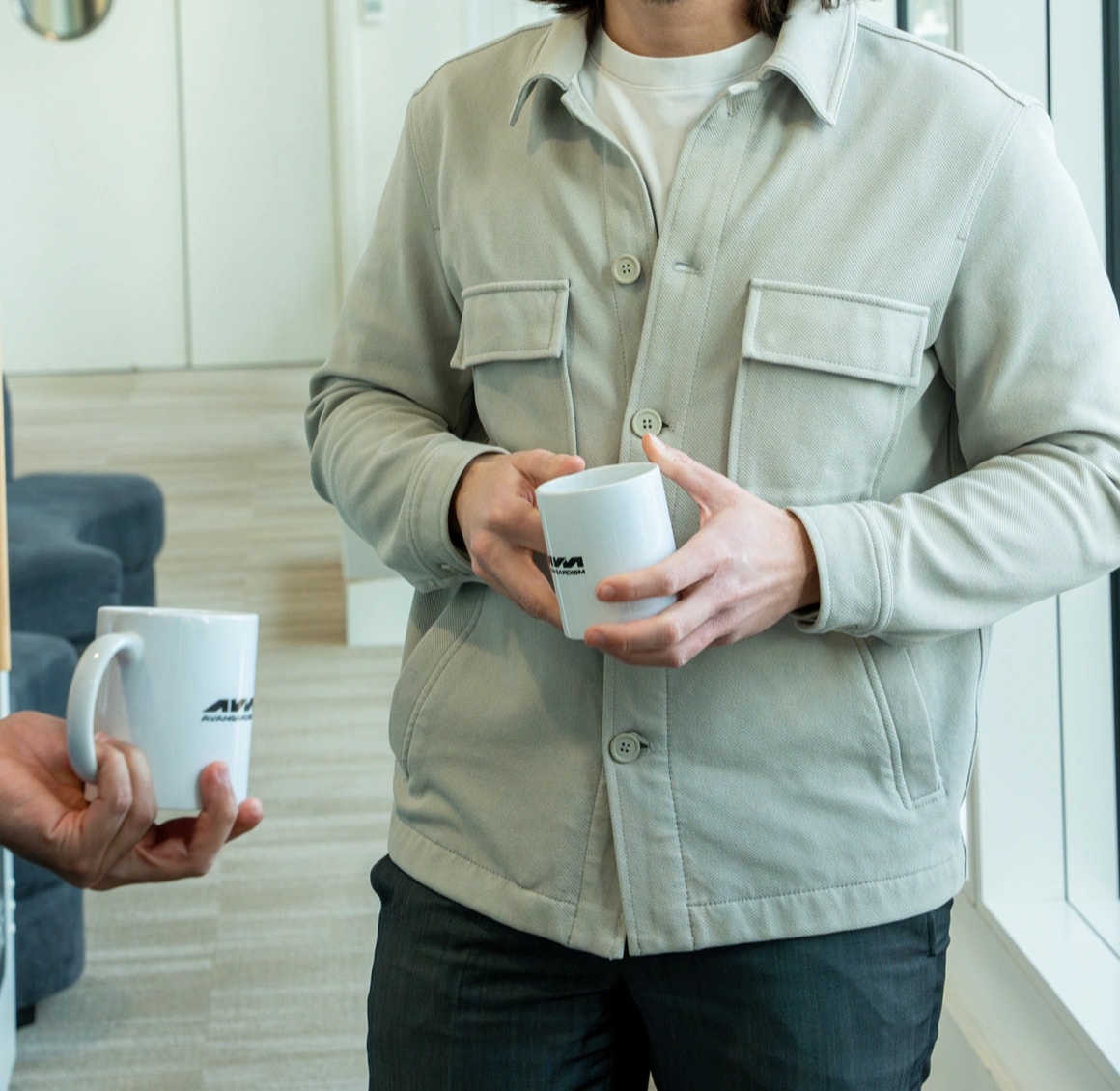 Deux membres de l'équipe trinquent avec des mugs AVANGARDISM