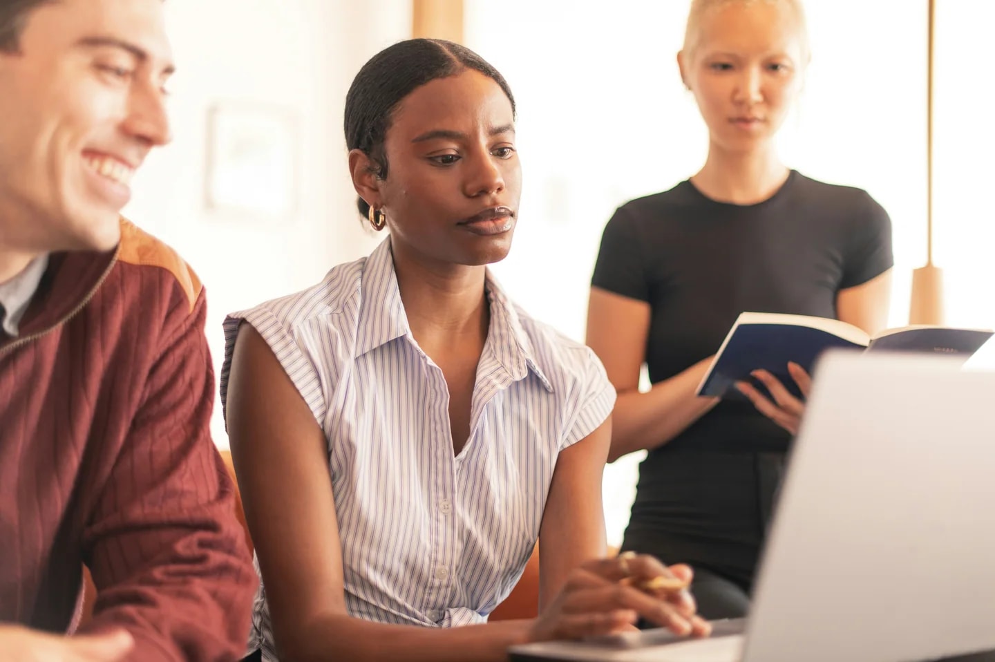 Échange entre collègues autour d’un ordinateur portable