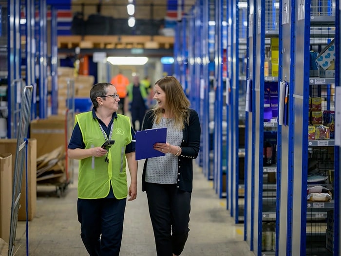 Échange entre deux professionnels dans un entrepôt logistique